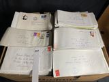 une boîte remplie de lettres et d'enveloppes posée sur une chaise
