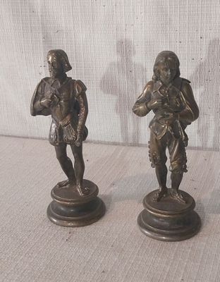 paire de figurines en bronze représentant un homme et une femme, posées sur un socle