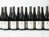 six bouteilles de vin sont alignées sur une table