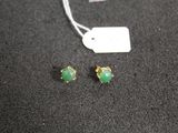 a pair of green stone stud earrings on a black surface