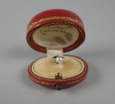 une petite boîte rouge contenant une perle