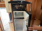 a man standing next to an open refrigerator in a kitchen