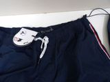 navy blue shorts with red and white stripes and a tag on the bottom