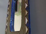 a mirror hanging on the wall with a blue border around it