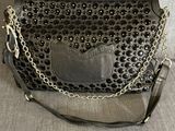 un sac à main noir avec une chaîne autour de la bandoulière et une chaîne autour de la bandoulière