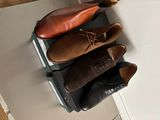 trois paires de chaussures posées sur une valise