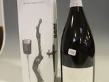 une bouteille de vin posée à côté d'un verre à vin sur une table