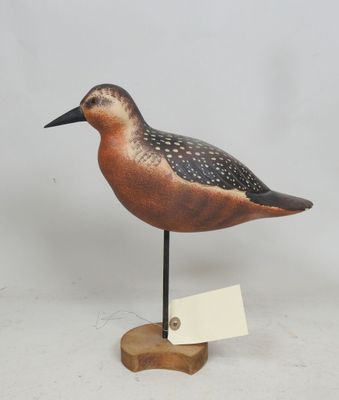 un petit oiseau posé sur un socle en bois