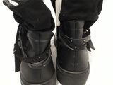 black leather boots with buckles on the side of them
