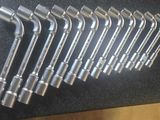 six wrenches that are lined up on a black surface