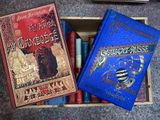 two books are sitting in a wooden box on the floor