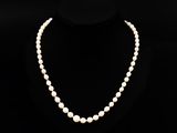un collier de perles blanches sur un mannequin noir