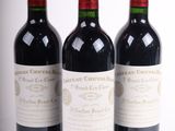 trois bouteilles de vin rouge posées l'une à côté de l'autre sur une surface blanche