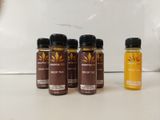quatre bouteilles de sirop de miel posées sur un plan de travail à côté d'une bouteille de sirop de miel