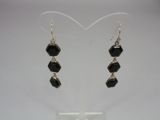a pair of black and silver earrings on a white background