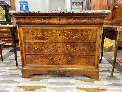 une commode en bois avec un plateau en marbre dans une pièce