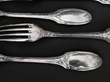 six forks and spoons are lined up on a black surface