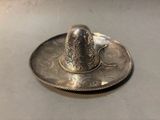 a silver plate with a silver bird on top of it