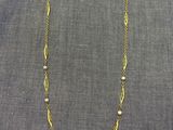 un collier en or orné de perles sur fond gris