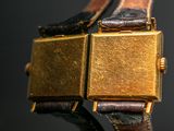 a close up of a gold watch with a black background