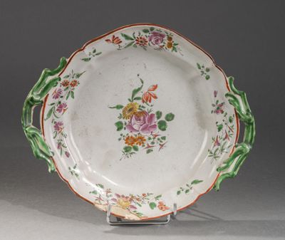 une assiette décorée de fleurs, posée sur un socle