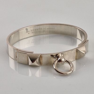 silver bracelet with a metal ring and a metal ring on a white surface