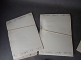 three pieces of paper with writing on them sitting on top of a table