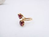 a close up of a gold ring with two red stones on it
