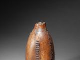 a close up of a wooden vase on a gray surface