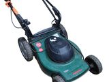 a green lawn mower sitting on top of a white surface