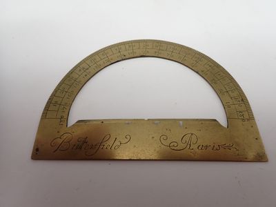 une vieille règle en laiton sur laquelle est inscrit quelque chose