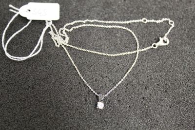 a close up of a silver necklace with a chain attached to it
