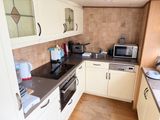 a small kitchen with white cabinets and a black counter top