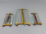 trois objets en verre et en laiton sont posés sur une table