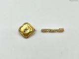 a close up of a gold pin with a flower on it