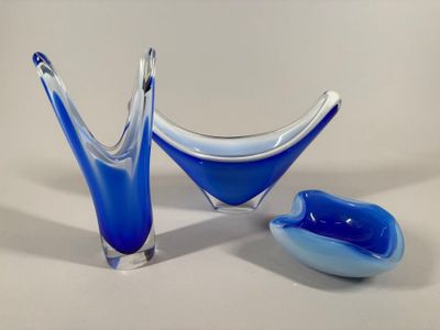 two blue glass bowls and a spoon on a table