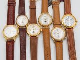 four different types of watches are lined up on a white surface