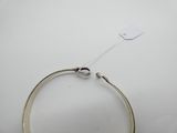 un gros plan d'un bracelet posé sur une surface blanche, avec une étiquette