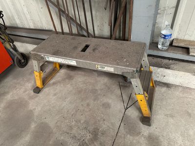 un banc en béton posé dans un garage, à côté d'une caisse à outils rouge