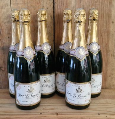 six bottles of champagne are lined up on a wooden shelf