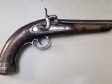 gros plan d'un pistolet sur une table à fond blanc