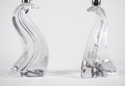 une paire de bougeoirs en verre transparent en forme de cygne sur fond blanc