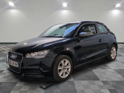 la voiture noire est garée sur un sol en damier dans le garage
