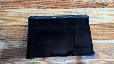 a black tablet computer sitting on a wooden table