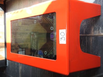 une boîte orange avec un autocollant, accrochée au mur