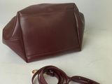 brown leather handbag with gold hardware and strap on a white background