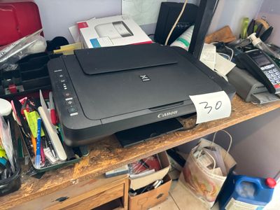 a printer sitting on top of a wooden desk next to other office supplies