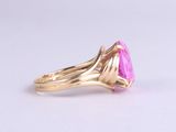 a close up of a pink stone ring on a white surface