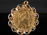 un pendentif en forme de pièce d'or sur lequel est gravé le visage d'une femme
