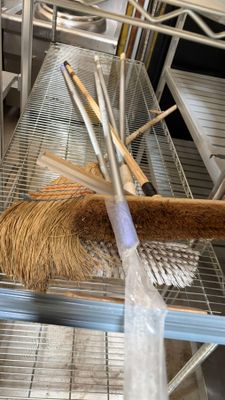 a broom that is sitting on a shelf in a room